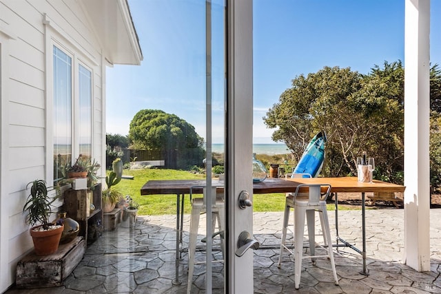 view of patio featuring a water view and fence