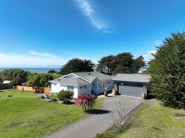 ranch-style home featuring a garage, a front lawn, fence, and aphalt driveway