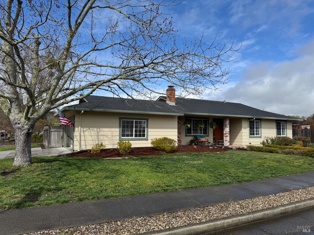 ranch-style home with a front yard, fence, and a chimney