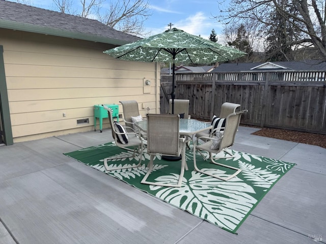 view of patio featuring outdoor dining space and fence