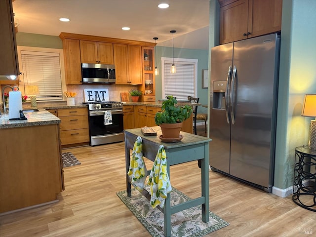 kitchen featuring recessed lighting, stainless steel appliances, decorative backsplash, pendant lighting, and light wood-type flooring