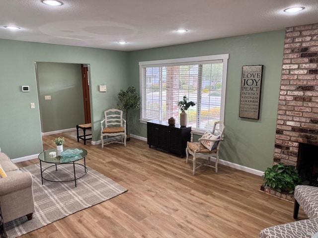 living area with recessed lighting, light wood-style floors, and baseboards