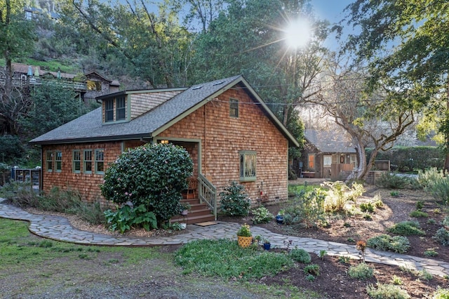 view of front facade with roof with shingles