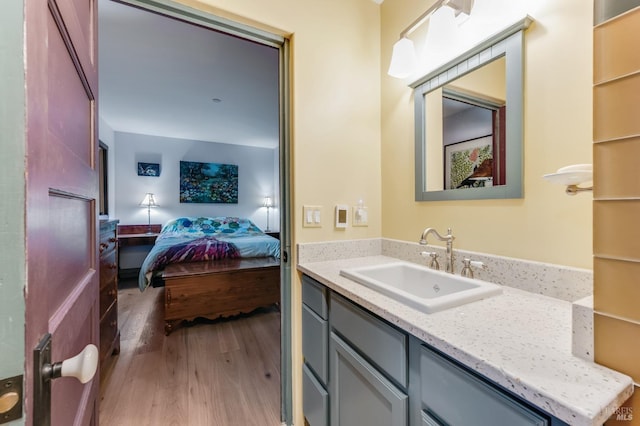 ensuite bathroom with wood finished floors, vanity, and connected bathroom