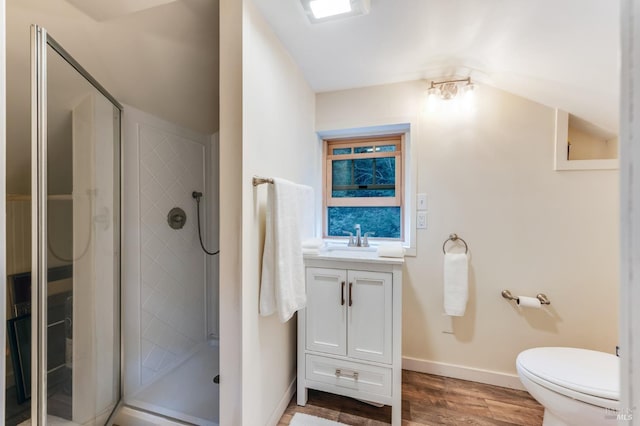 bathroom featuring toilet, a stall shower, wood finished floors, and vanity