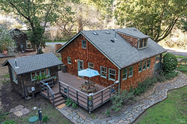 rear view of property with a shingled roof and a wooden deck