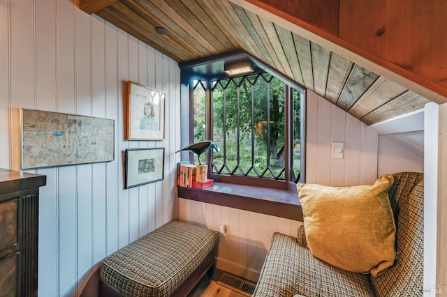 interior space with lofted ceiling, wooden ceiling, and wooden walls