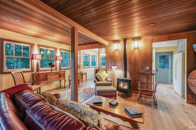 living room with wood ceiling, a wood stove, wooden walls, and wood finished floors