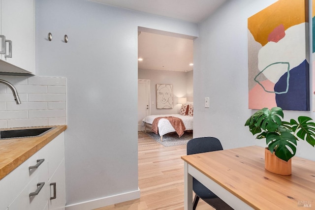 dining area with light wood-type flooring and baseboards