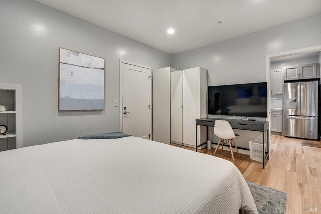 bedroom featuring recessed lighting, stainless steel fridge, and light wood-style flooring