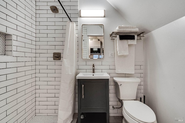 full bath with decorative backsplash, toilet, vaulted ceiling, a tile shower, and vanity
