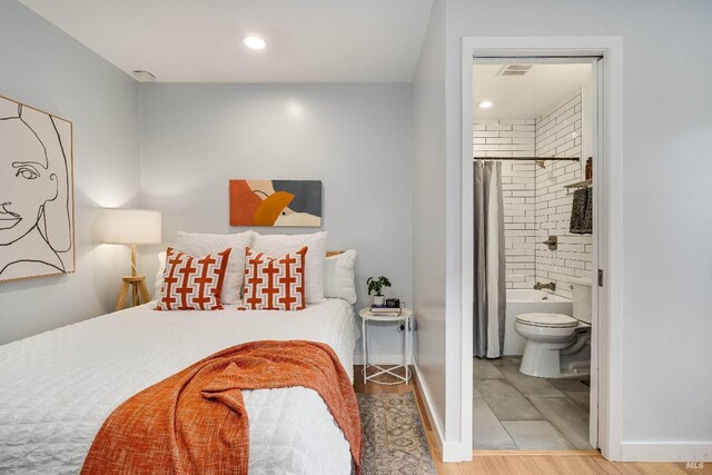 bedroom with recessed lighting, visible vents, ensuite bath, wood finished floors, and baseboards