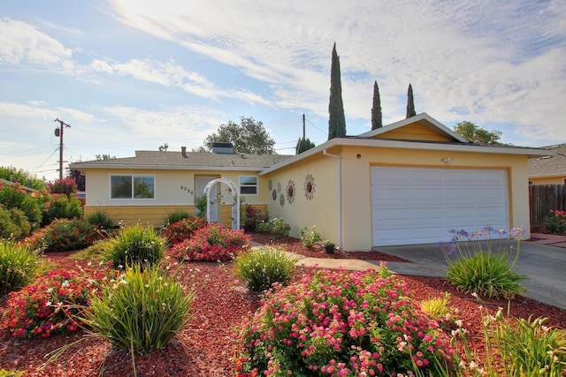 ranch-style house with concrete driveway, an attached garage, fence, and stucco siding