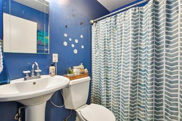 full bathroom with a shower with curtain, toilet, and a sink