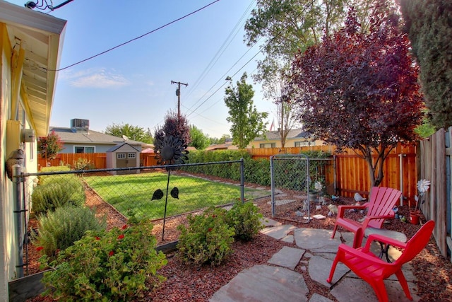 view of yard with a storage unit, an outdoor structure, and a fenced backyard