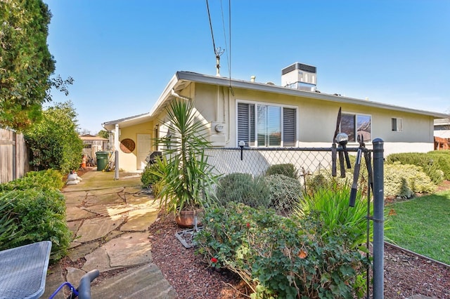 exterior space featuring stucco siding and fence