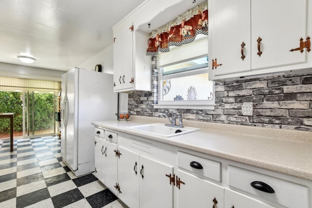 kitchen with a sink, a wealth of natural light, light floors, and white cabinets