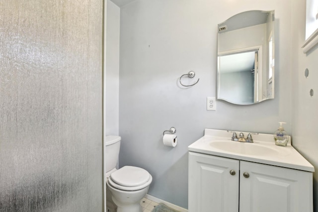 bathroom with tile patterned floors, toilet, vanity, and baseboards