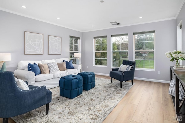 living area with baseboards, visible vents, crown molding, light wood-type flooring, and recessed lighting