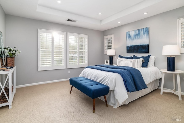 bedroom with a tray ceiling, recessed lighting, visible vents, and baseboards