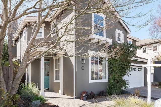 traditional home featuring a garage and stucco siding