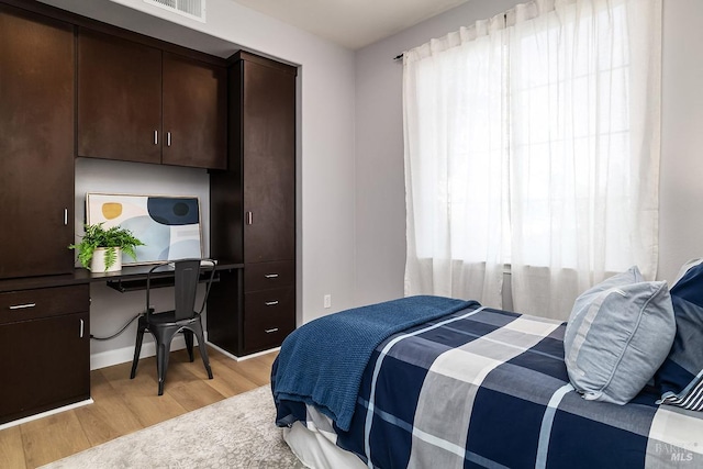 bedroom featuring light wood-style floors, multiple windows, and visible vents