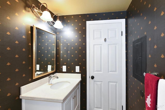 bathroom featuring wallpapered walls and vanity