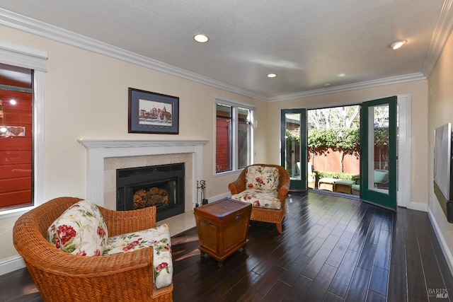 living area with dark wood-style floors, a fireplace, ornamental molding, and baseboards