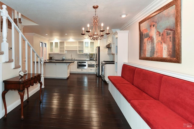 interior space with dark wood-type flooring, crown molding, and an inviting chandelier