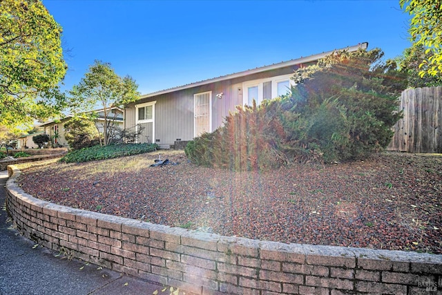 view of front of property featuring crawl space and fence