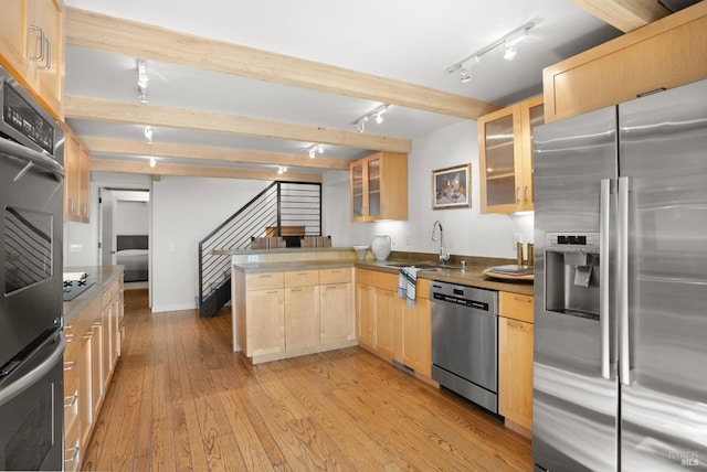 kitchen featuring beam ceiling, light brown cabinetry, appliances with stainless steel finishes, light wood-type flooring, and a peninsula