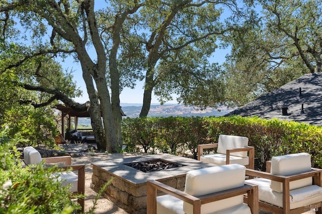 view of patio with an outdoor fire pit and a mountain view