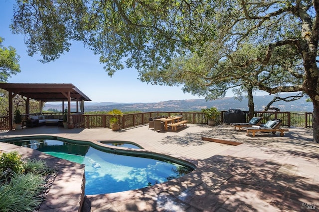 view of swimming pool featuring a deck, a gazebo, and an in ground hot tub