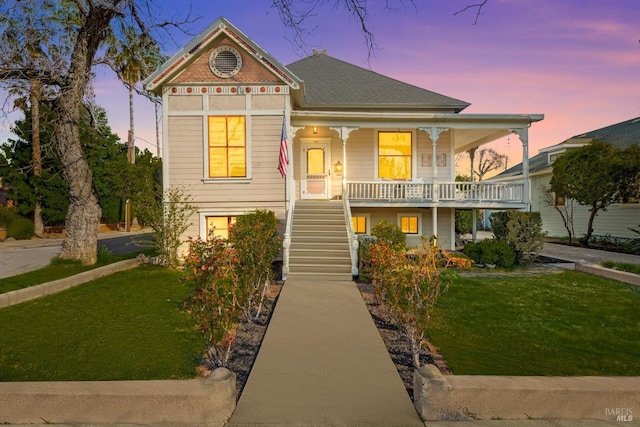 victorian-style house featuring a front lawn, stairway, and covered porch