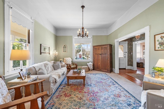 living area with a notable chandelier, baseboards, and wood finished floors