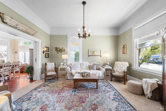 living area with a notable chandelier, baseboards, and wood finished floors