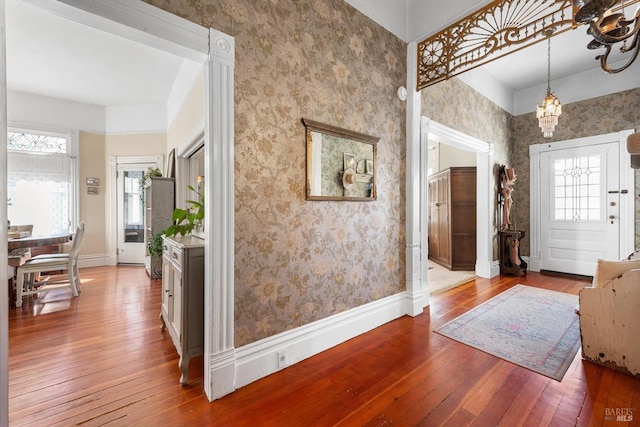 foyer entrance featuring baseboards, hardwood / wood-style flooring, and wallpapered walls