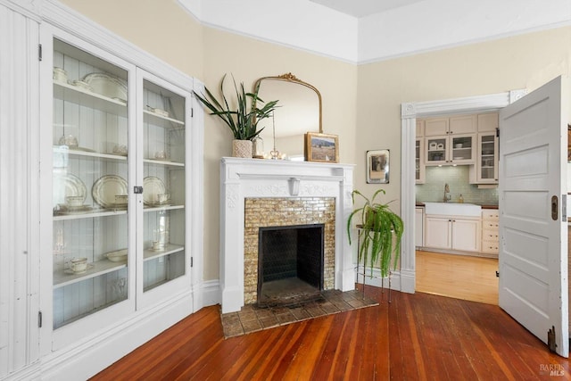 dining room with an inviting chandelier, hardwood / wood-style flooring, a fireplace, and baseboards