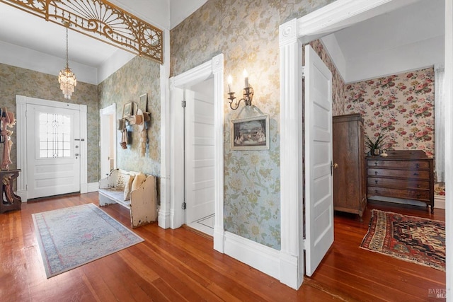 entrance foyer featuring wallpapered walls and hardwood / wood-style flooring