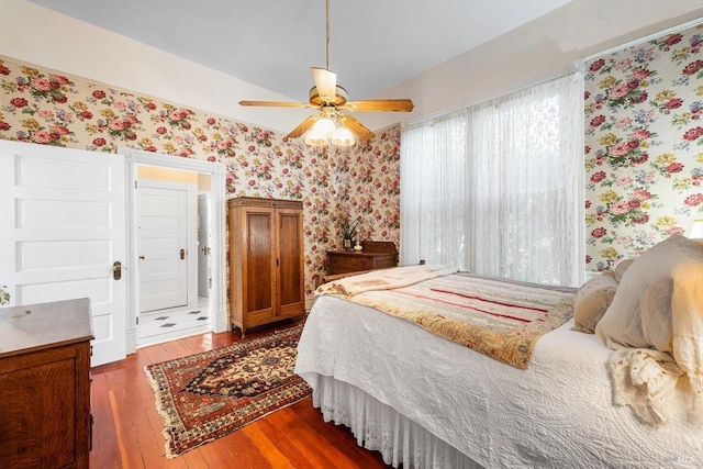 bedroom with baseboards, hardwood / wood-style flooring, and wallpapered walls