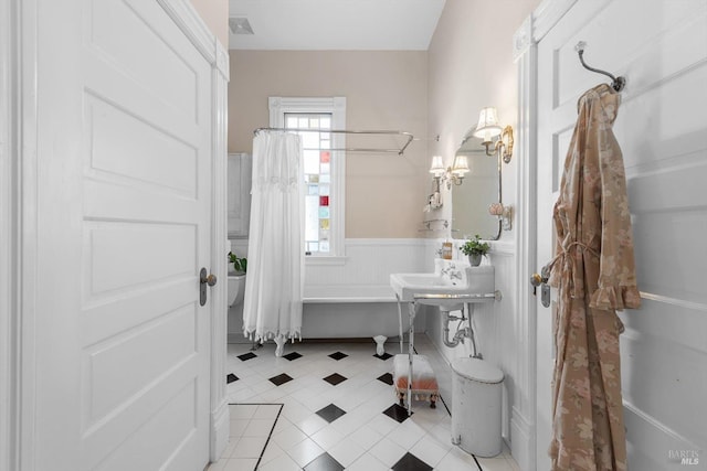 bathroom with tile patterned floors and wainscoting