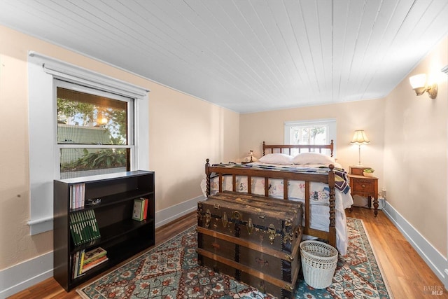 bedroom featuring wooden ceiling, wood finished floors, and baseboards