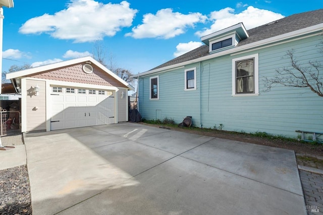 view of side of home with a detached garage and an outdoor structure