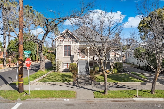 victorian house with stairs and a front yard