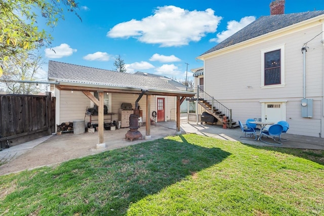 back of property featuring a patio, stairway, fence, a yard, and a chimney