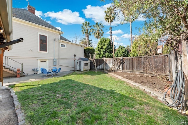 view of yard featuring a storage unit, a patio, an outdoor structure, and a fenced backyard