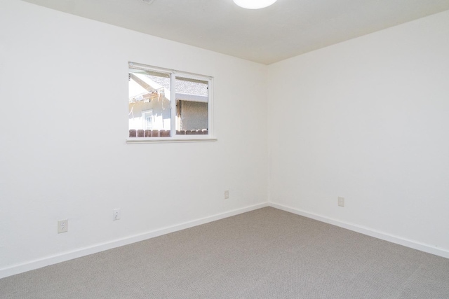 empty room featuring baseboards and carpet