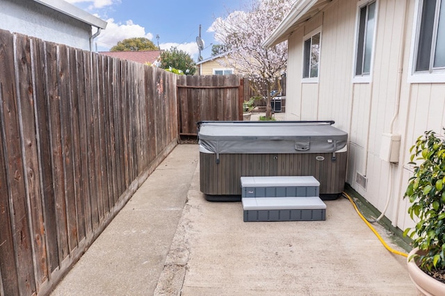 view of patio / terrace featuring a fenced backyard and a hot tub