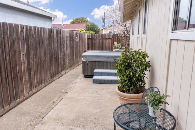 view of patio featuring a fenced backyard and a hot tub