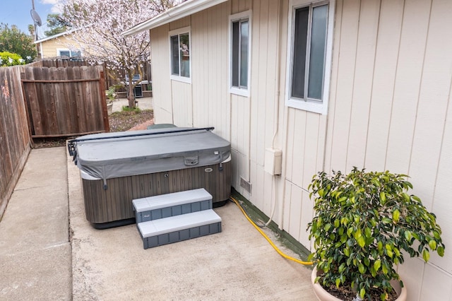 view of patio featuring fence and a hot tub